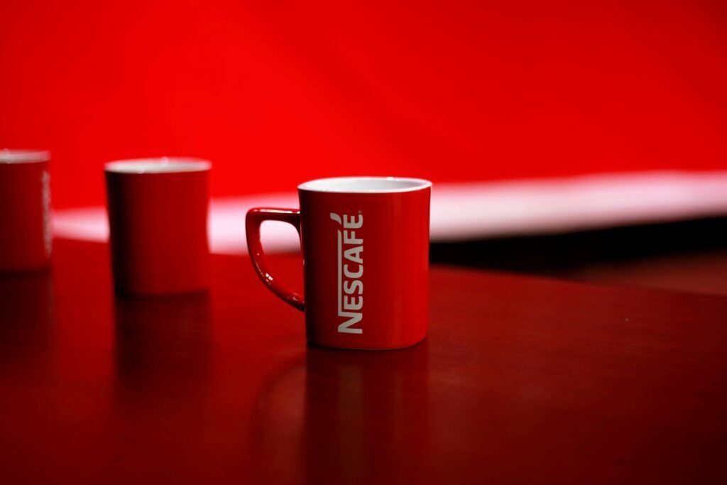 Bright red coffee mug featuring bold branding on a clean studio background.